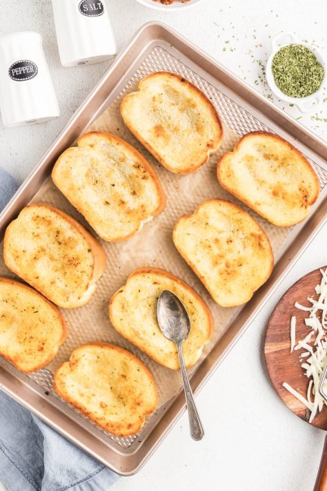 A spoon making wells on baked pieces of Texas Toast.