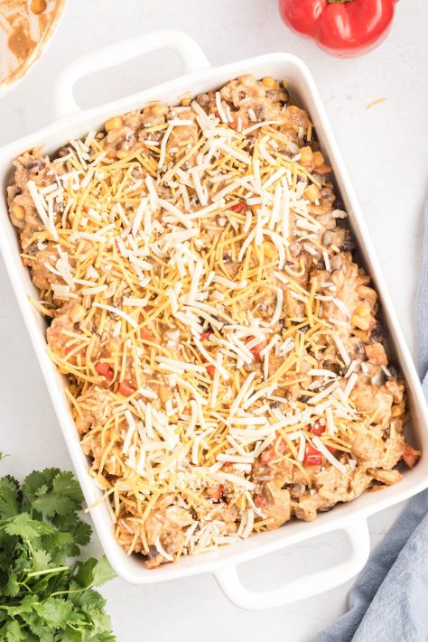 Layers of a chicken mixture and cheese with tortillas in a baking dish.