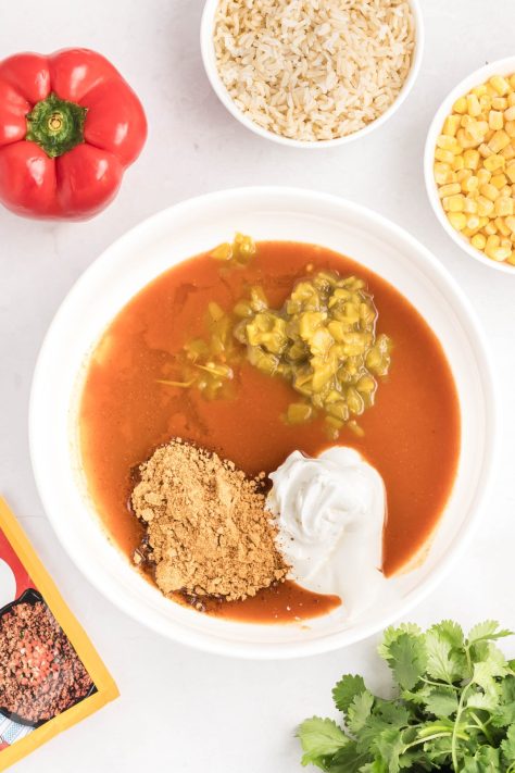 A bowl of enchilada sauce, chicken broth, sour cream, green chiles, and taco seasoning.