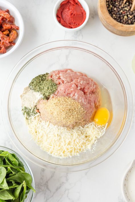 meatball mixture showing in a large, clear mixing bowl.