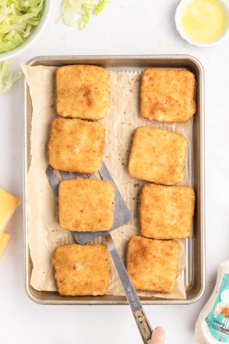 Fish filets on a lined baking sheet.