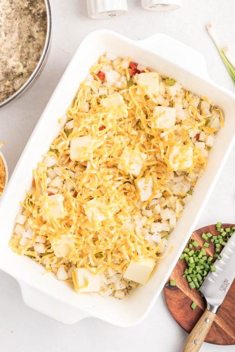A baking dish with potatoes, cheese and butter.