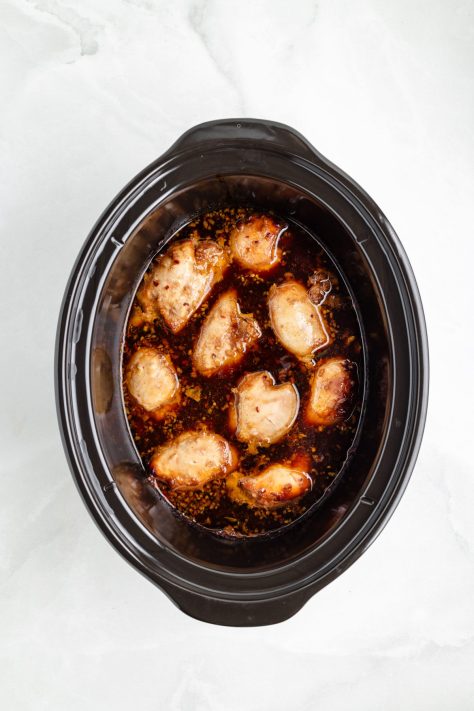 Cooked chicken in a Slow Cooker with sauce.