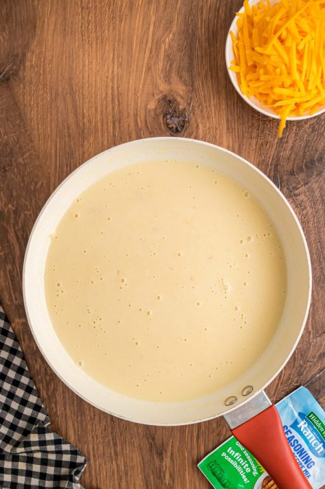 Cheese sauce being made in a saucepan.