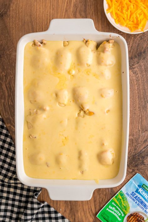Cheese sauce covering chicken crescent rolls.