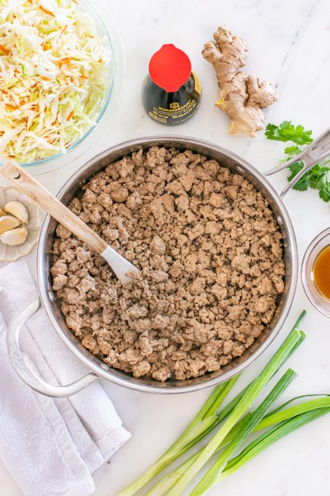 Ground pork cooking in a skillet.