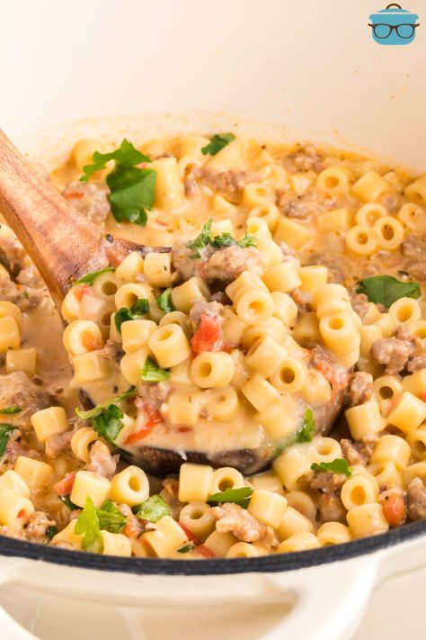 A soup ladle getting a scoop of Creamy Italian Sausage Soup from the pot.