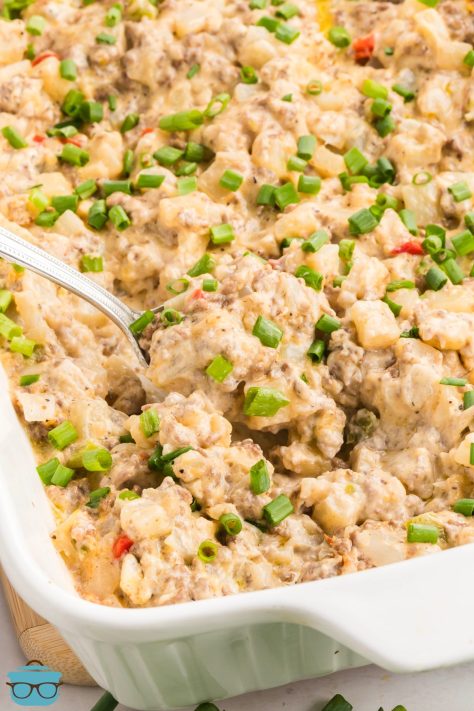 A large baking dish with a spoon getting a scoop of Patio Potatoes.