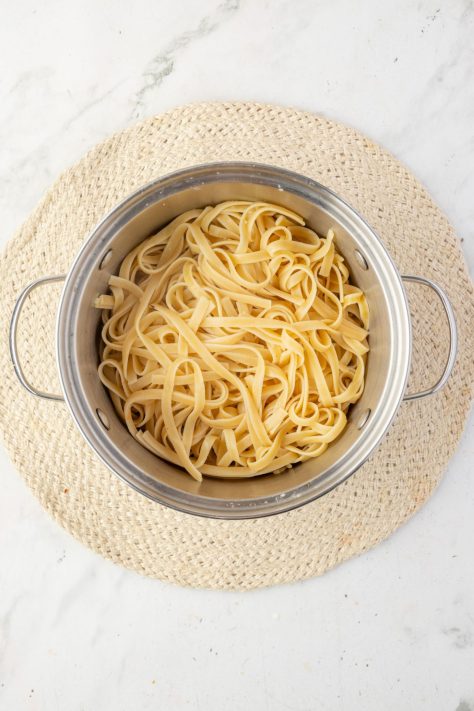 Cooked pasta draining in a colander.