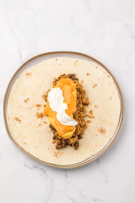 Tortilla shells with cheese, nacho sauce, beef, and sour cream.