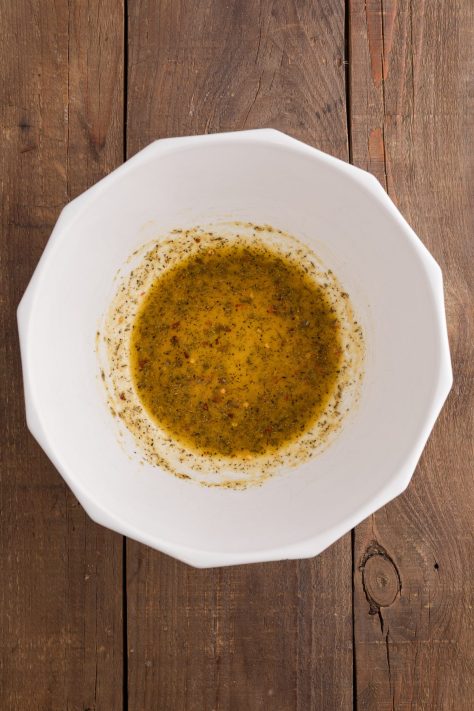 A bowl of seasonings and oil mixed together.