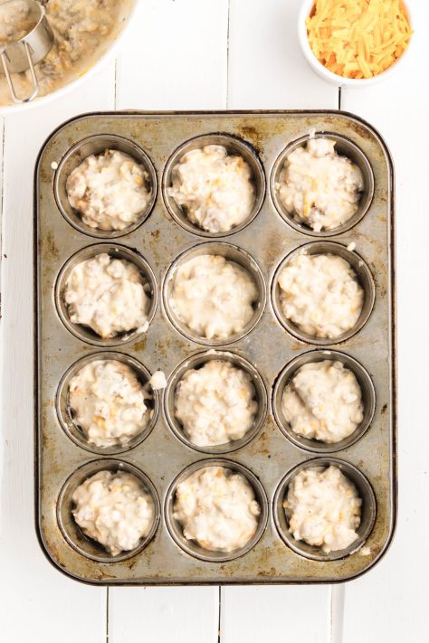Muffin batter in a greased muffin tin.