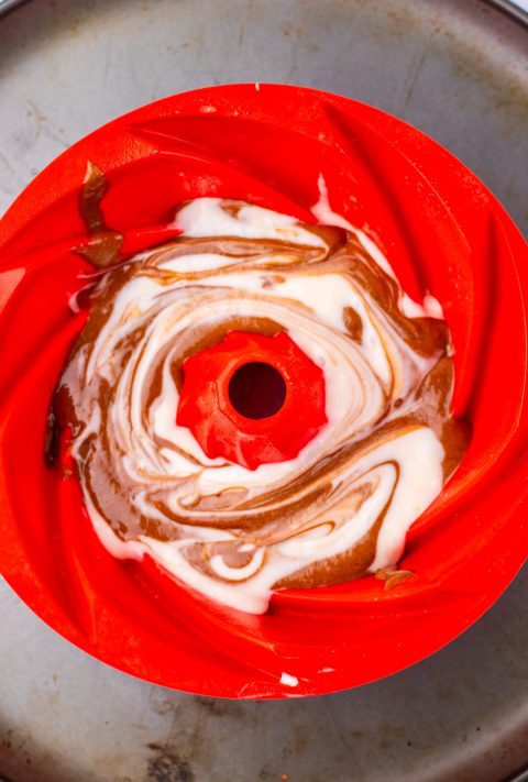 Cake batter being spread in a cake pan.