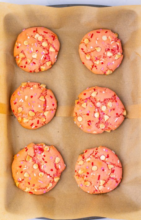 Baked Strawberry Cookies on a parchment paper lined tray.