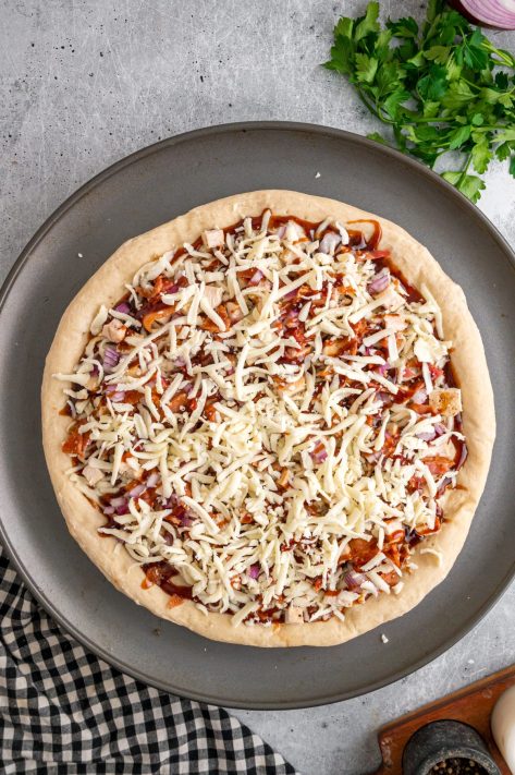 Layered unbaked BBQ Chicken Pizza.