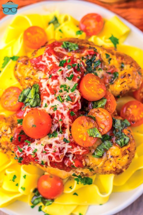 A full plate of Buschetta Chicken over pasta.