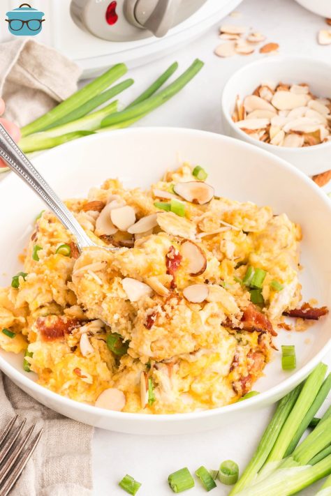 A spoon getting a large scoop of Crock Pot Neiman Marcus Chicken Casserole.