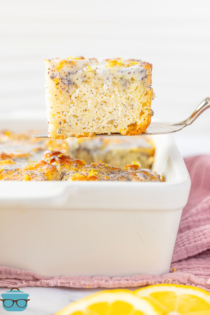 A serving utensil getting a large Lemon Poppyseed Butter Swim Biscuit from the dish.