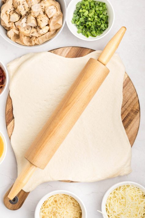 Pizza dough rolled out with a rolling pin.