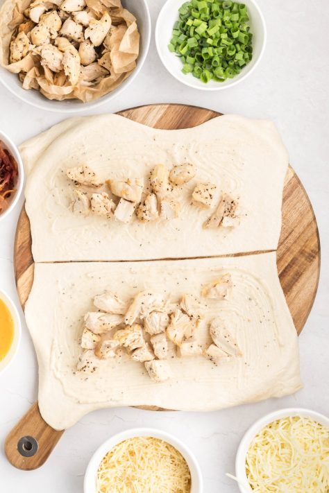 Chicken and caesar dressing on pizza dough.