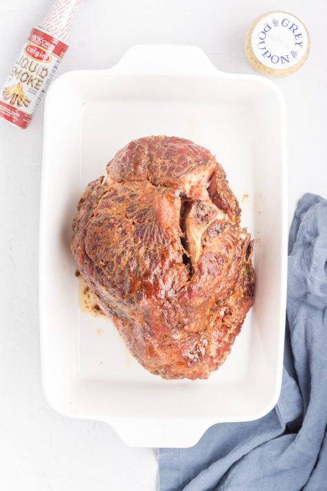 A cooked ham in a baking dish.
