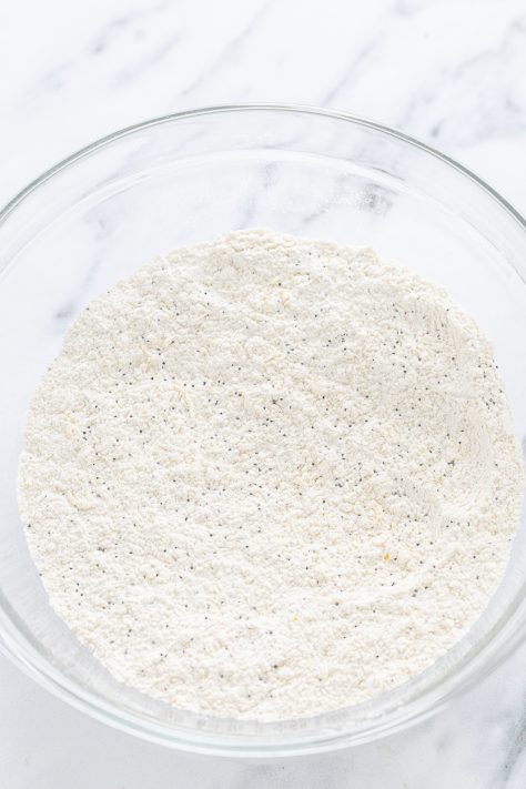 Flour, baking powder, salt, and poppy seeds in a bowl.