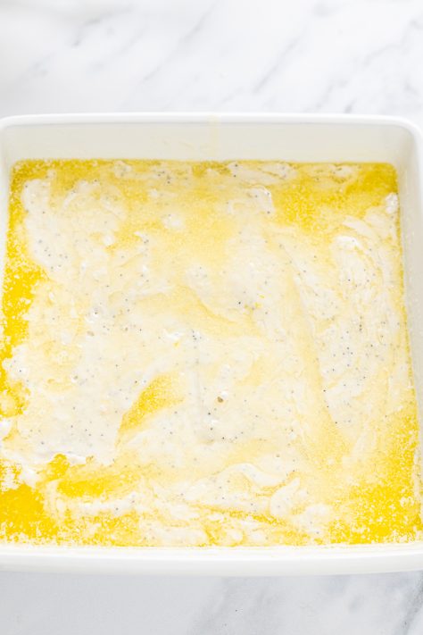 Batter and melted butter in baking dish.