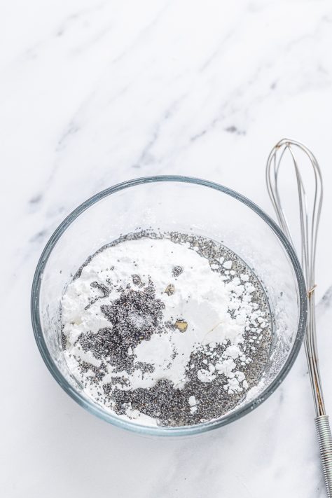 Lemon poppy seed glaze being mixed in a bowl.