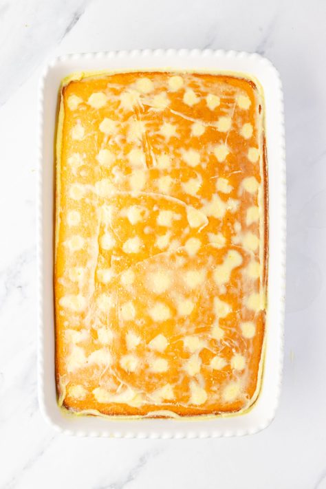 A cake with holes filled with pudding.