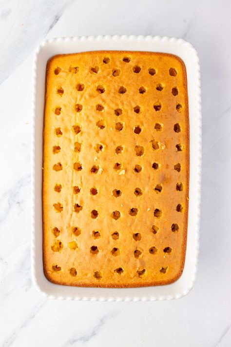 A cake with holes in a baking dish.