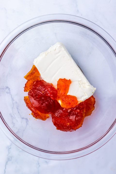 Pepper jelly and cream cheese in a bowl.