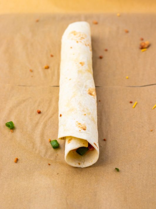 A rolled up tortilla with filling.