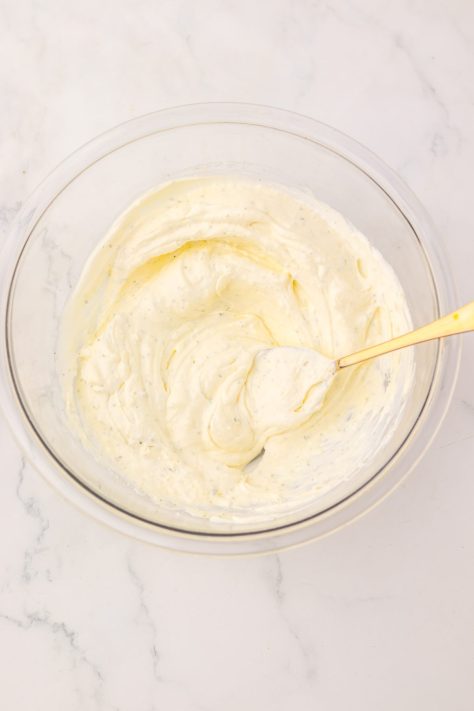 A bowl of cream cheese, sour cream, and ranch seasoning.