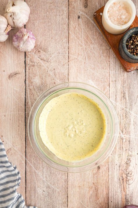 A bowl of caesar and pesto mixed together.