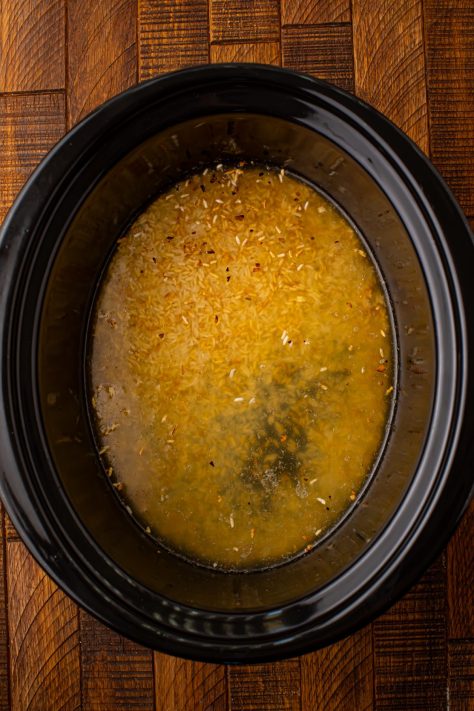 Rice, garlic, broth, and seasonings in a Slow Cooker.