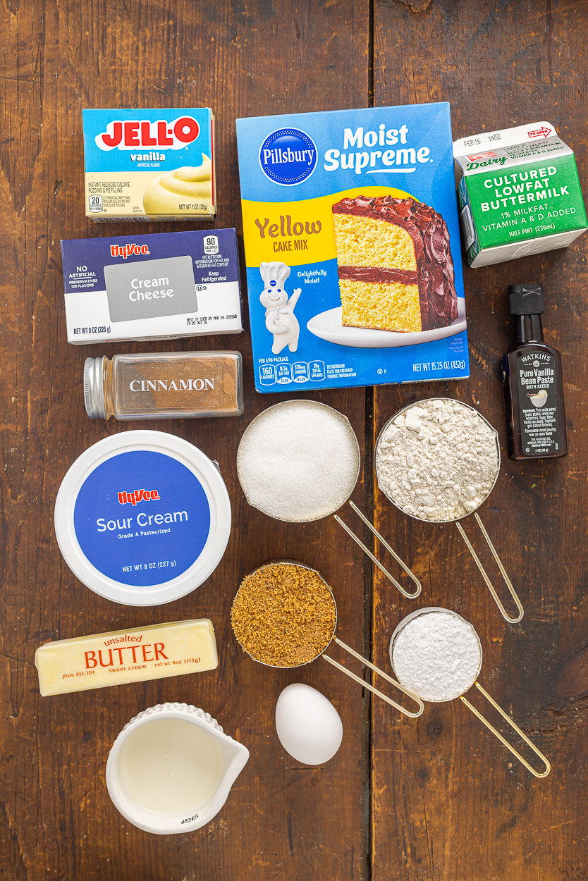 Yellow cake mix, all purpose flour, instant vanilla pudding mix, granulated sugar, unsalted butter, buttermilk, sour cream, eggs, vanilla bean paste or vanilla extract, dark brown sugar, ground cinnamon, cream cheese, powdered sugar, and heavy whipping cream.