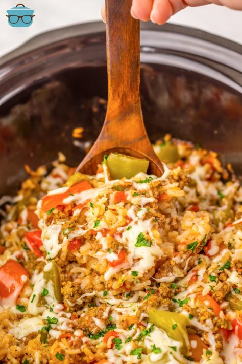 A wooden spoon getting a scoop of Stuffed Pepper Casserole from the Slow Cooker.