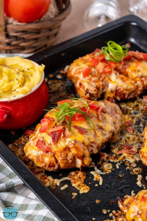 A sheet pan with a few pieces of Monterey Chicken and a bowl of mashed potatoes.