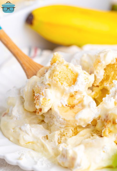 A wooden serving spoon getting a scoop of Pound Cake Banana Pudding.