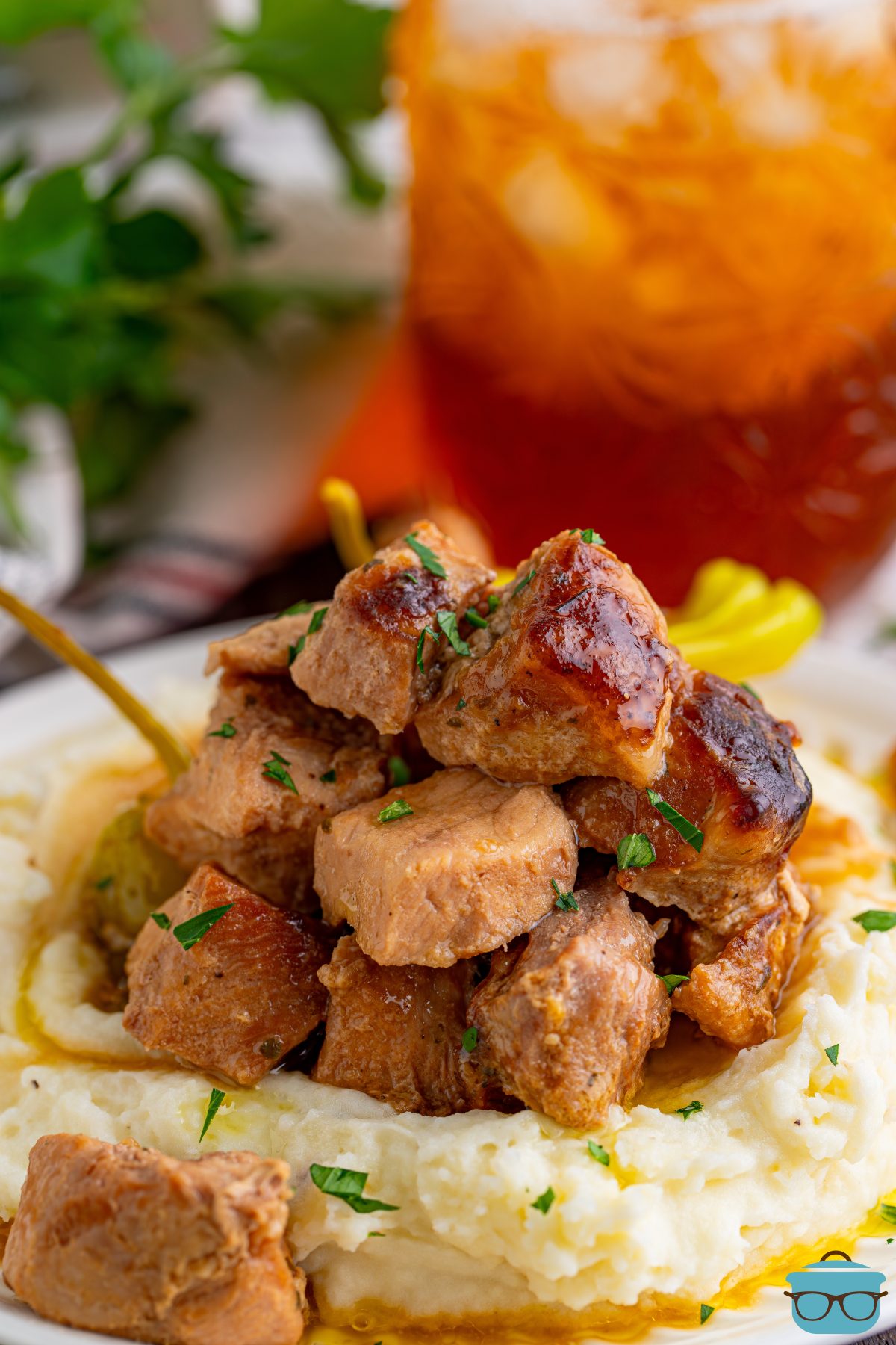 A pile of mashed potatoes with a bunch of Crock Pot Mississippi Pork Bites.