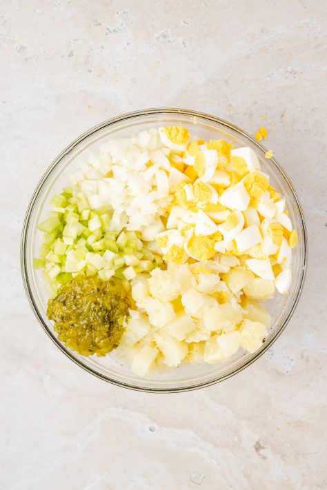 All ingredients for an Amish Potato Salad in a bowl to be mixed.