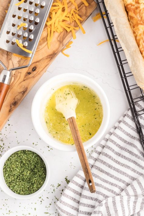A garlic butter and herb mixture with a pastry brush.
