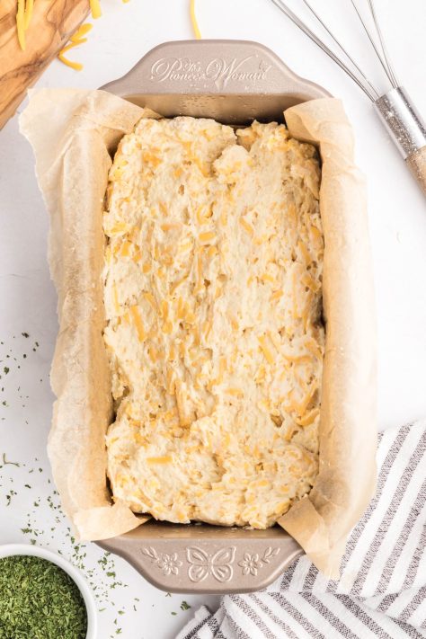 A lined baking pan with Cheddar Bay Biscuit Bread dough.