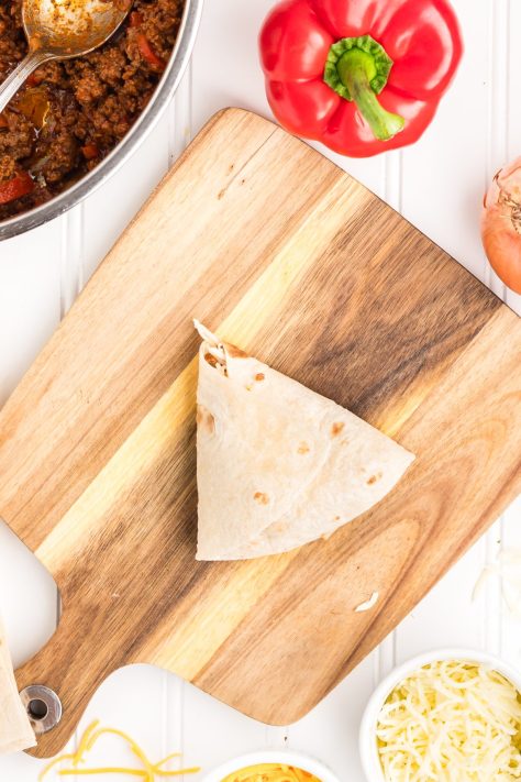 Folded tortilla pocket with meat and cheese mixture.