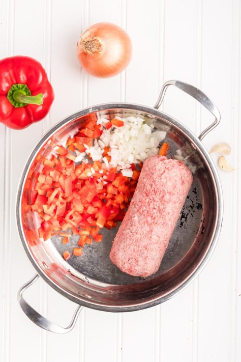 A ground beef, onion, and pepper mixture in a pan to cook.