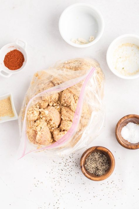 Breadcrumb mixture coated chicken in a bag.