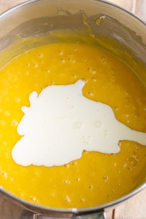 Milk being added to cake batter in a bowl.