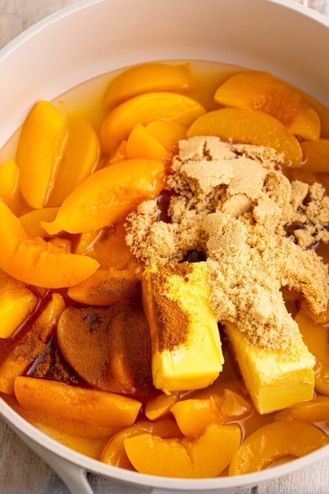Peaches, sugar, vanilla, and butter in a pan.