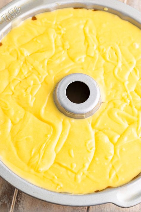 Layers of cake batter and peaches in a bundt pan.