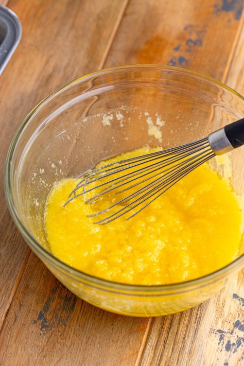 Butter, flour, and sugar being mixed in a bowl with a whisk.